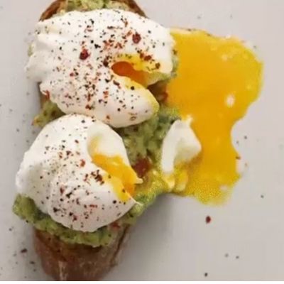 Toast à l'avocat avec œufs pochés sur une assiette blanche